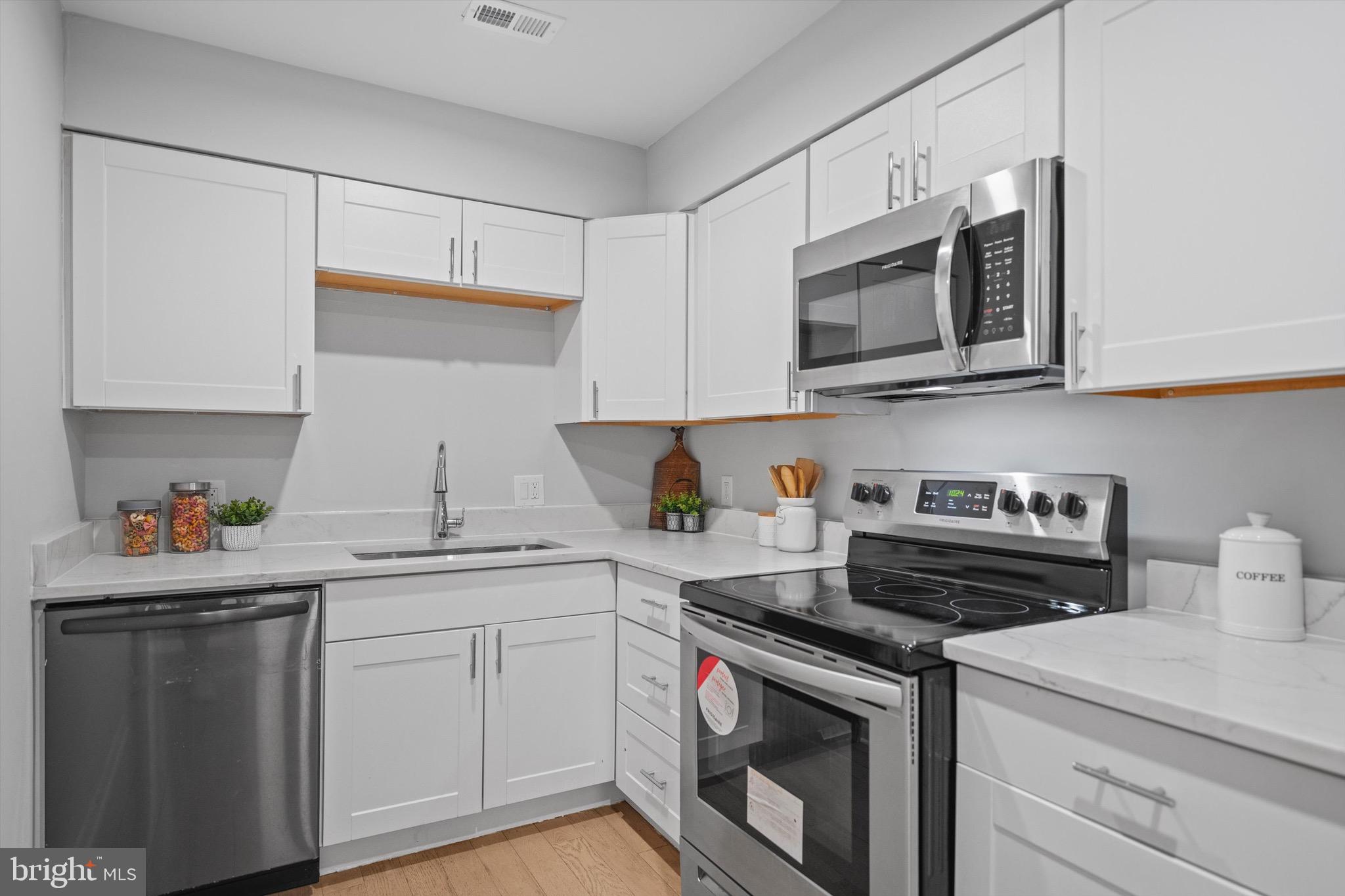 3114 Berry Road Northeast, Unit 21 Washington, DC 20018 - Photo 12 of 25 a kitchen with stainless steel appliances a stove a sink and cabinets