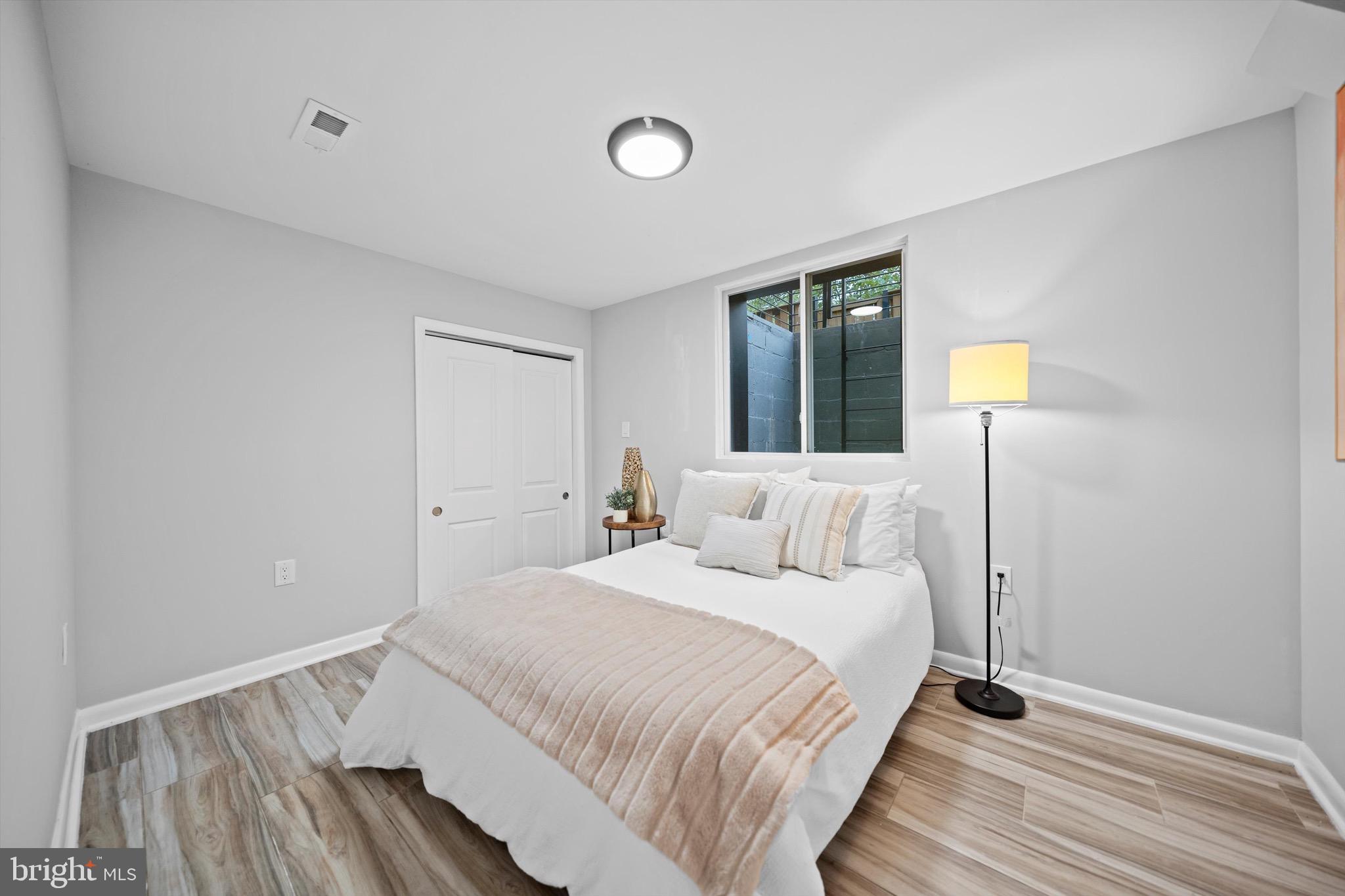 3114 Berry Road Northeast, Unit 21 Washington, DC 20018 - Photo 19 of 25 a bedroom with a bed and a lamp on table
