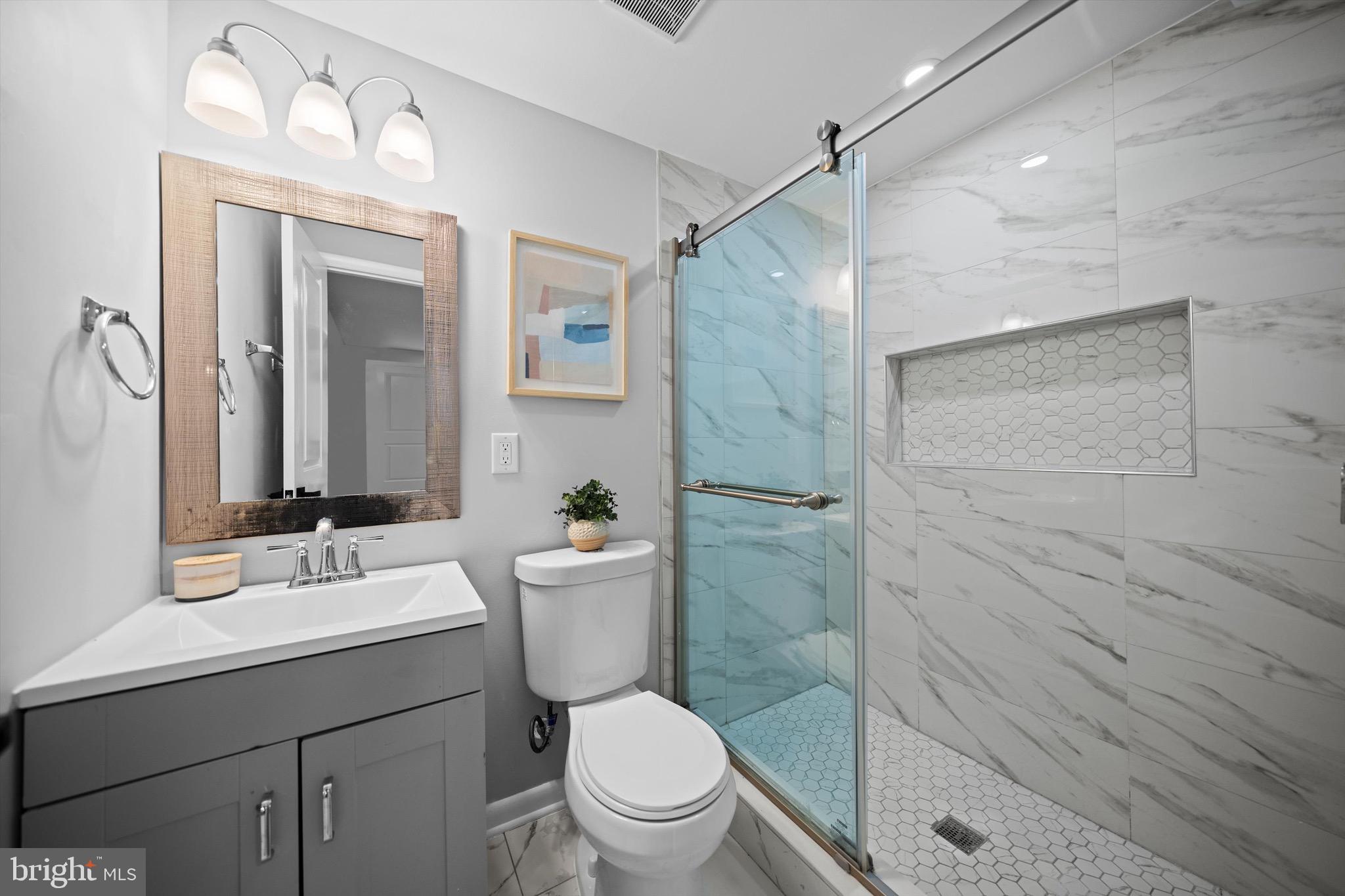 3114 Berry Road Northeast, Unit 21 Washington, DC 20018 - Photo 5 of 25 a bathroom with a sink mirror toilet and vanity