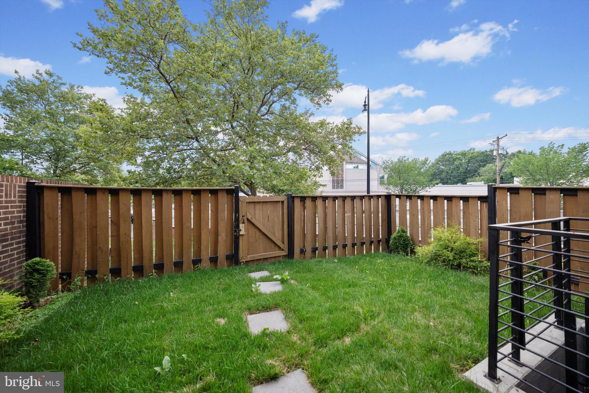 3114 Berry Road Northeast, Unit 21 Washington, DC 20018 - Photo 6 of 25 a view of a backyard with potted plants and wooden fence
