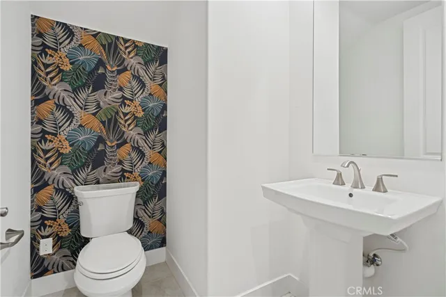 a white toilet sitting next to a bathroom sink