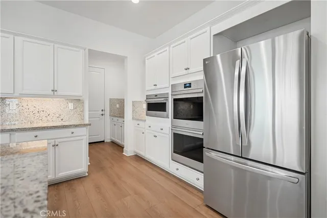 a kitchen with stainless steel appliances a refrigerator sink and cabinets