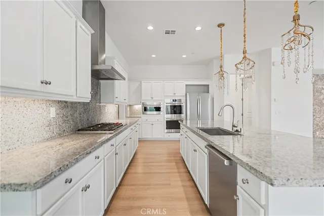 a large kitchen with stainless steel appliances granite countertop a sink a stove and a granite counter tops