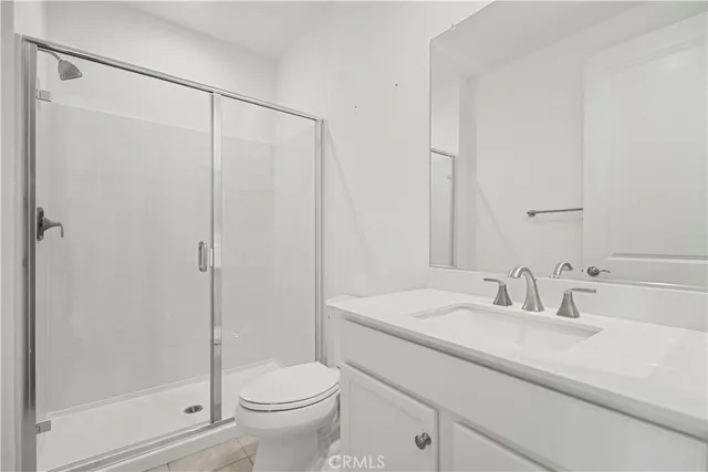 a bathroom with a shower sink vanity mirror and toilet