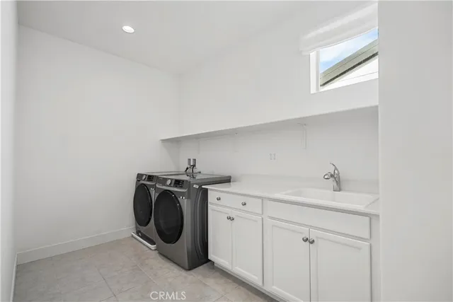 a utility room with sink dryer and washer