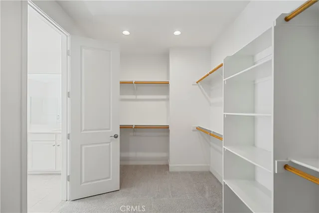 a view of walk in closet with empty racks