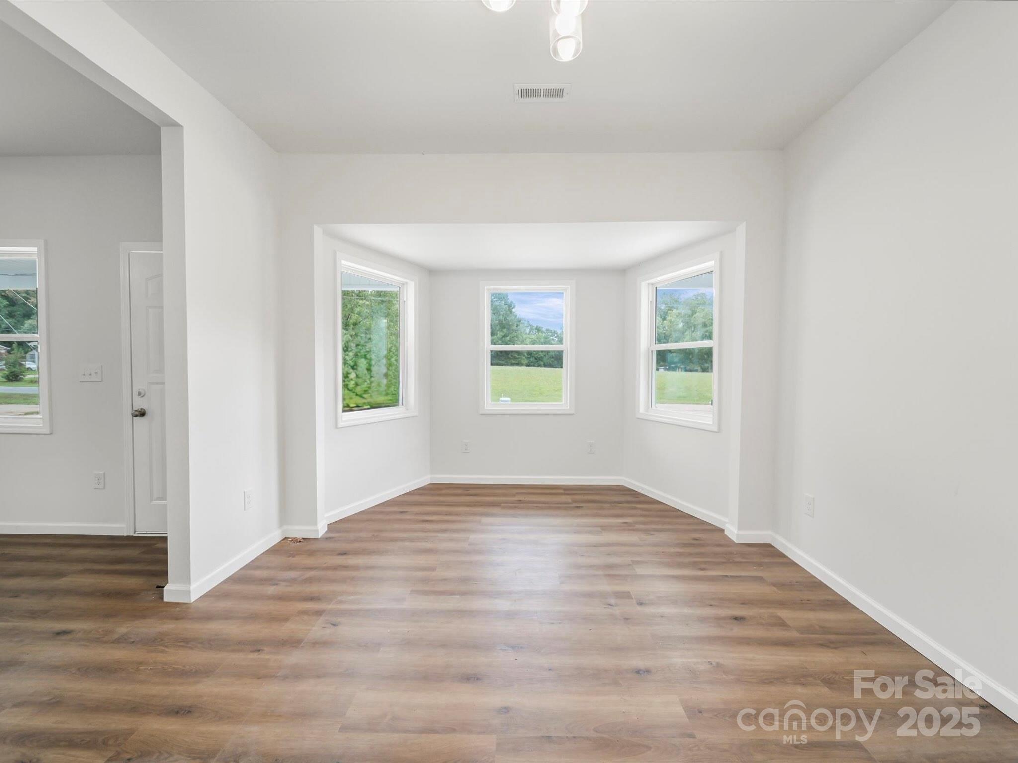 334 South Pink Street Cherryville, NC 28021 - Photo 6 of 25 an empty room with wooden floor and windows