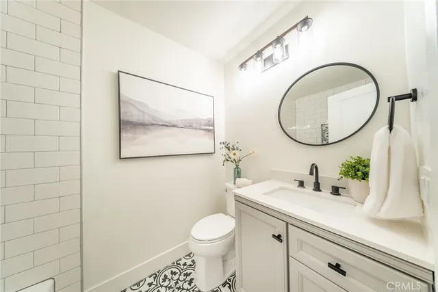 a bathroom with a toilet sink vanity and mirror