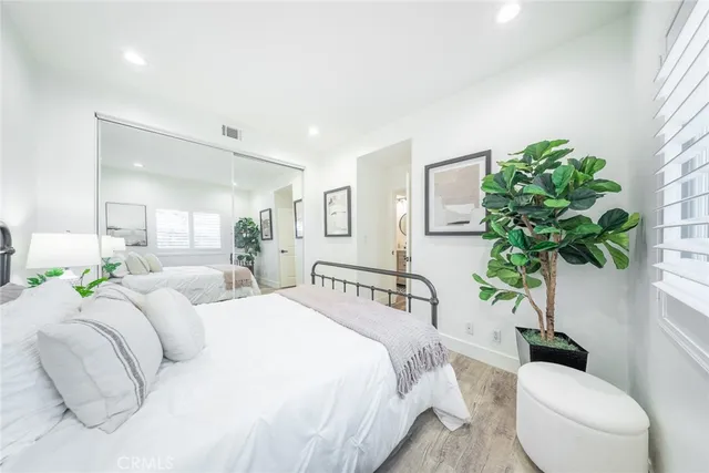 a bedroom with bed and a potted plant