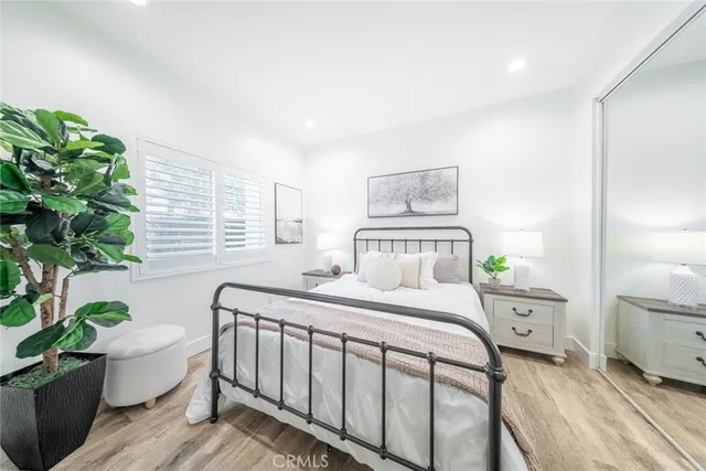 a bedroom with a bed and a potted plant
