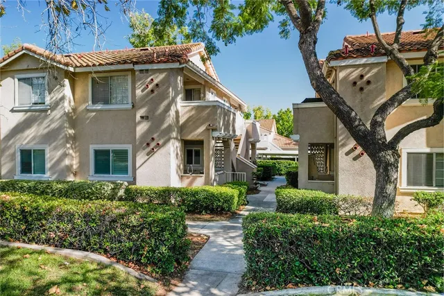 a view of a white house with large windows and a table and chairs