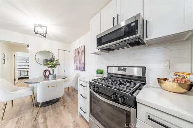 a kitchen with a stove a microwave and wooden floor