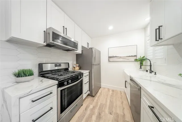 a kitchen with stainless steel appliances a sink stove and refrigerator