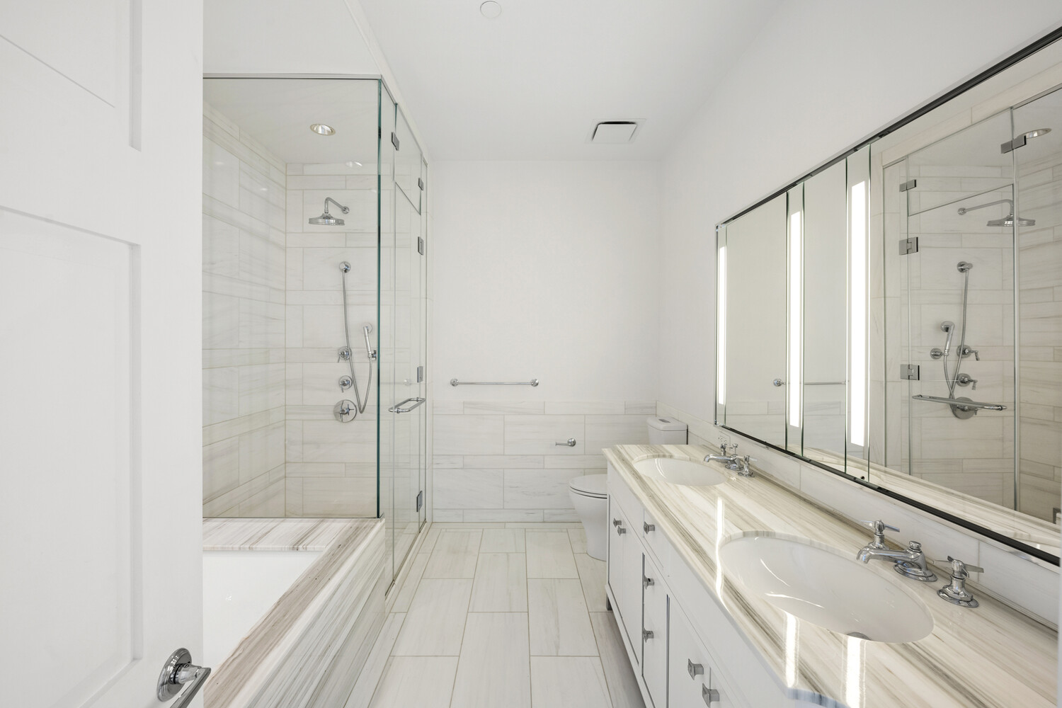 30 Park Place, Unit 61C Manhattan, NY 10007 - Photo 8 of 14 a spacious bathroom with a granite countertop sink a mirror a bathtub and shower