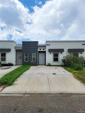 a front view of a house with a yard and a garage