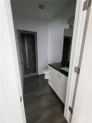 a view of empty room with wooden floor and window