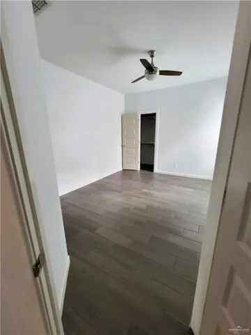 wooden floor in an empty room with a ceiling fan