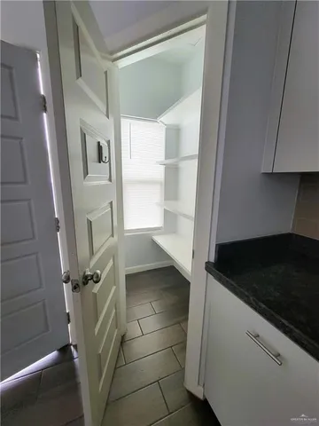 a white kitchen with sink and wooden floor