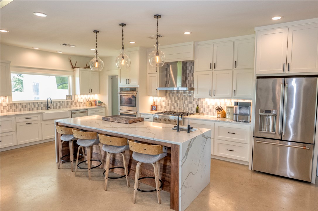 7105 Watermelon Road Somerville, TX 77879 - Photo 15 of 40 a kitchen with stainless steel appliances granite countertop a refrigerator a sink dishwasher a stove and white cabinets with wooden floor