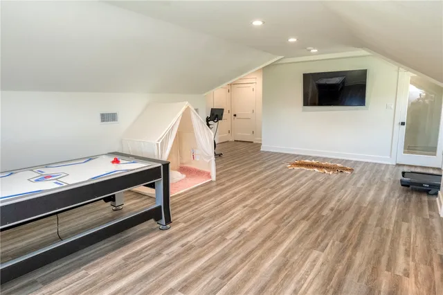 a bedroom with wooden floor and gym equipment