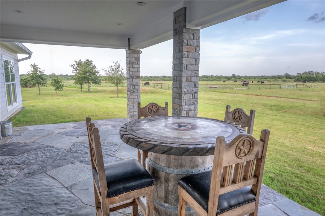 7105 Watermelon Road Somerville, TX 77879 - Photo 35 of 40 a view of a patio with a table chairs and a lake view