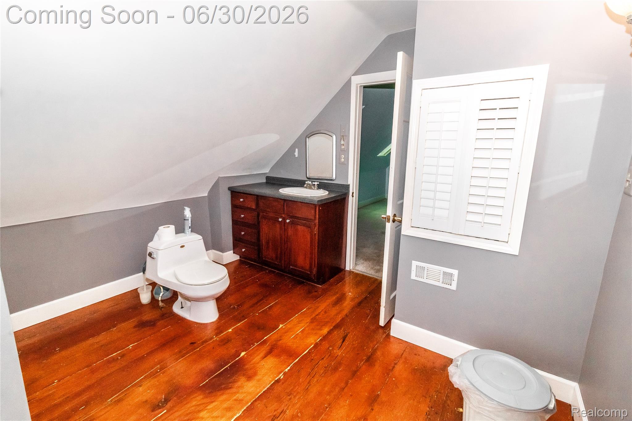 8150 Norman Road Imlay City, MI 48444 - Photo 29 of 58 Bathroom featuring wood-finish flooring, a dark wood-finish vanity with a built-in sink, and a mirrored medicine cabinet