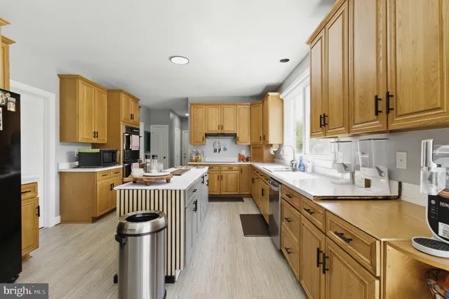 a kitchen with a sink appliances cabinets and a window