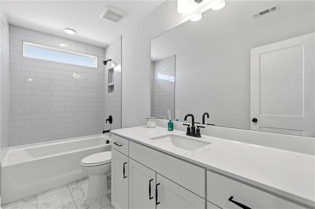 203 Sunshower Ridge Canton, GA 30114 - Photo 31 of 58 a bathroom with a sink a toilet a shower and a mirror