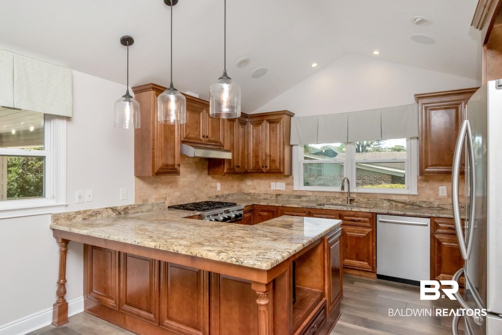 231 Rochester Road Mobile, AL 36608 - Photo 8 of 51 Kitchen featuring a peninsula, wood finish cabinets, backsplash, light stone counters, and dark wood-style floors
