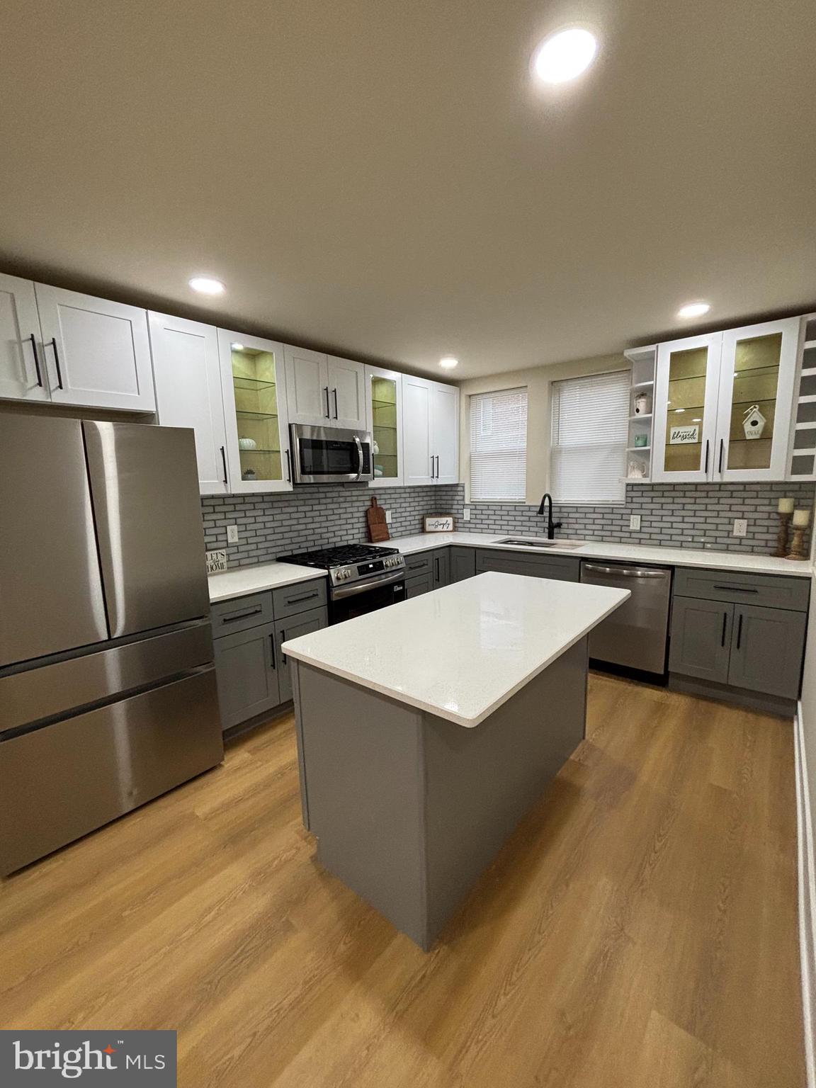 a kitchen with stainless steel appliances granite countertop a refrigerator a sink a stove a microwave a counter space and cabinets