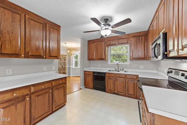a kitchen with kitchen island granite countertop a sink window and cabinets