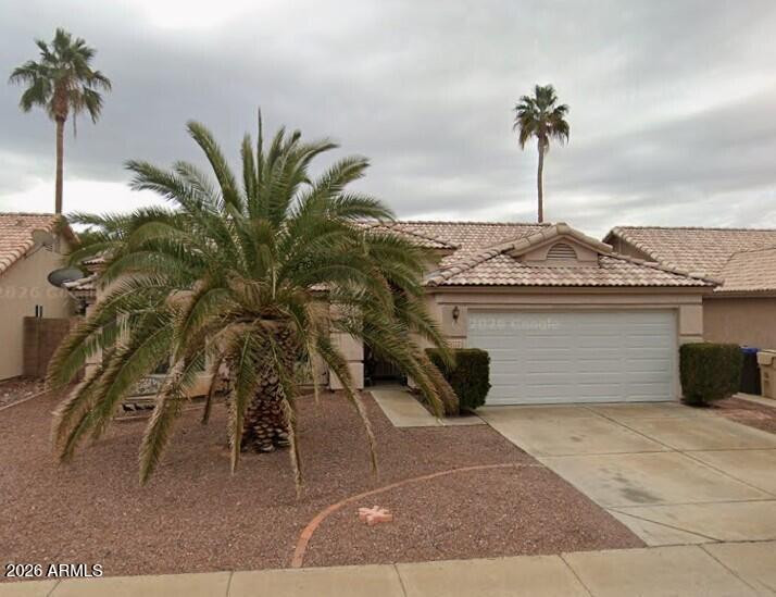 9163 West Davis Road Peoria, AZ 85382 - Photo 2 of 24 a front view of a house with a garden and a yard