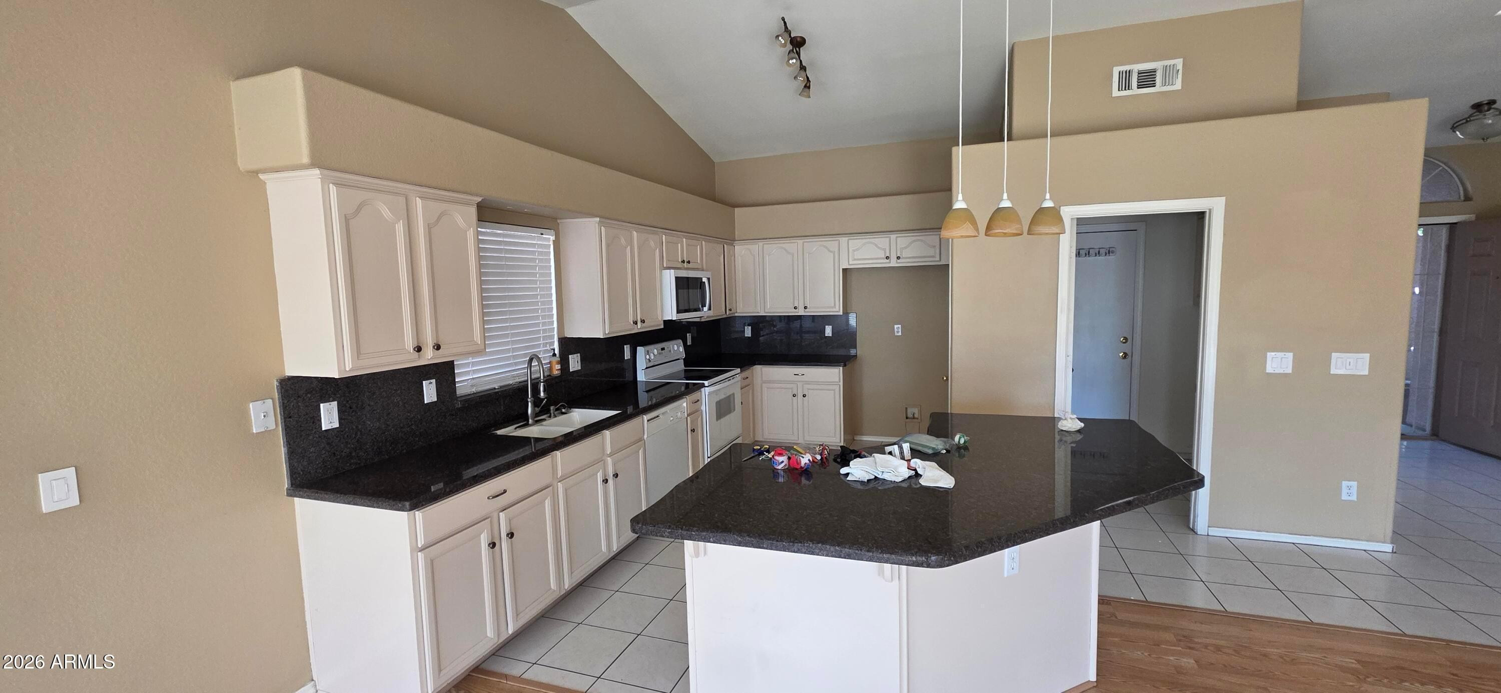 9163 West Davis Road Peoria, AZ 85382 - Photo 4 of 24 a kitchen with stainless steel appliances kitchen island granite countertop a sink and cabinets