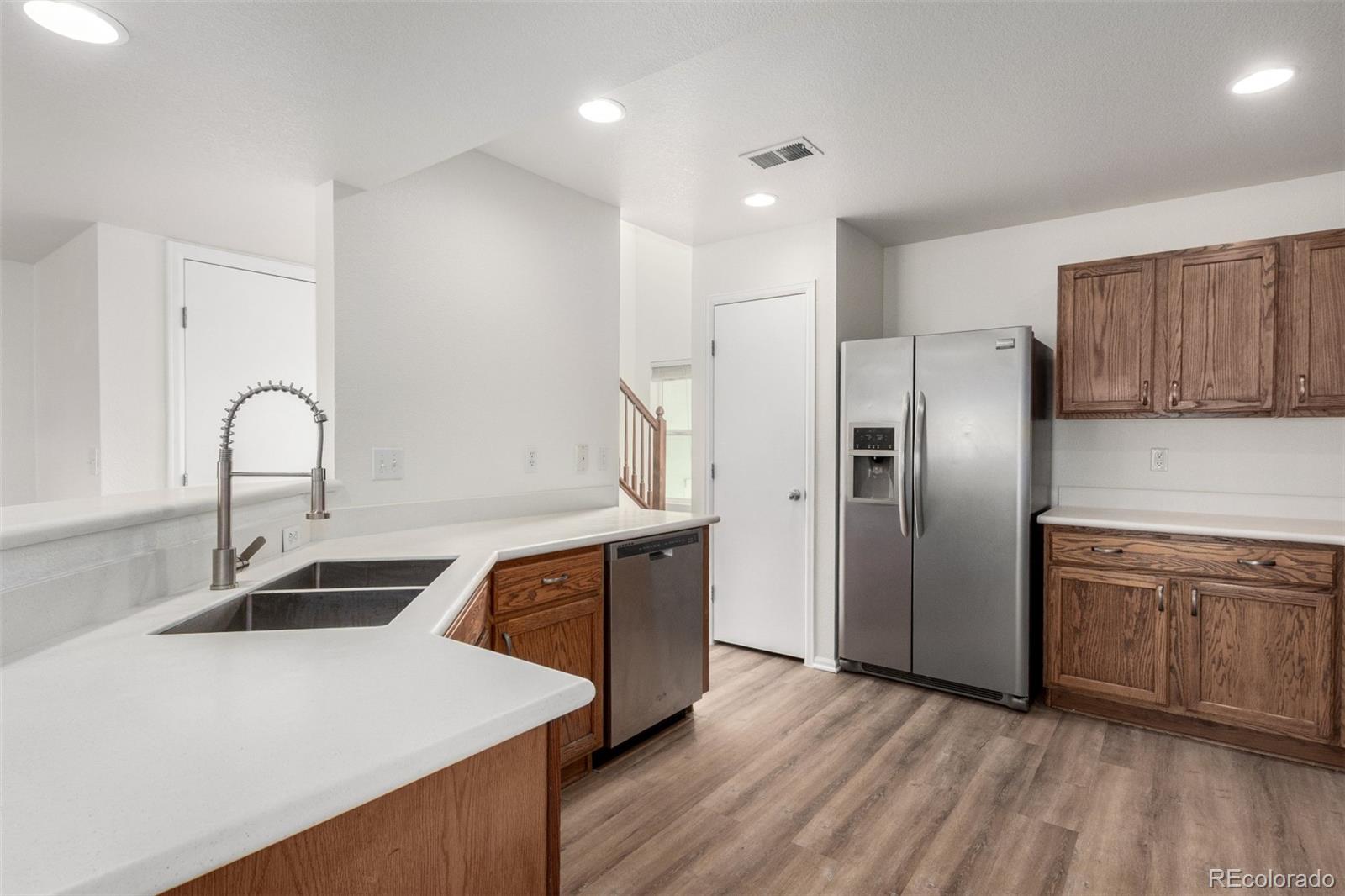 5850 Ceylon Street, Unit D Denver, CO 80249 - Photo 12 of 33 a kitchen with stainless steel appliances a sink and a refrigerator