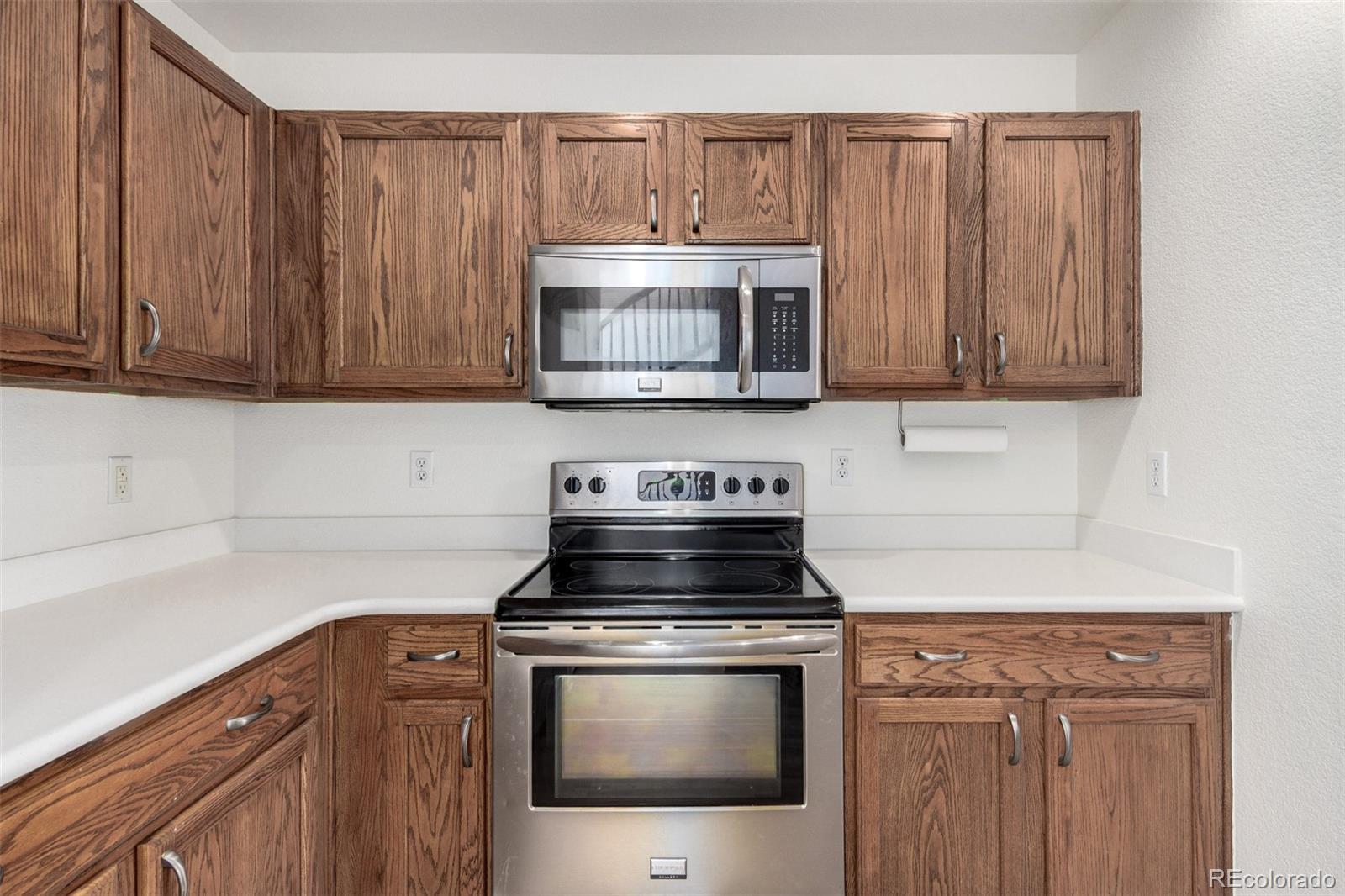 5850 Ceylon Street, Unit D Denver, CO 80249 - Photo 13 of 33 a kitchen with granite countertop a stove and a microwave