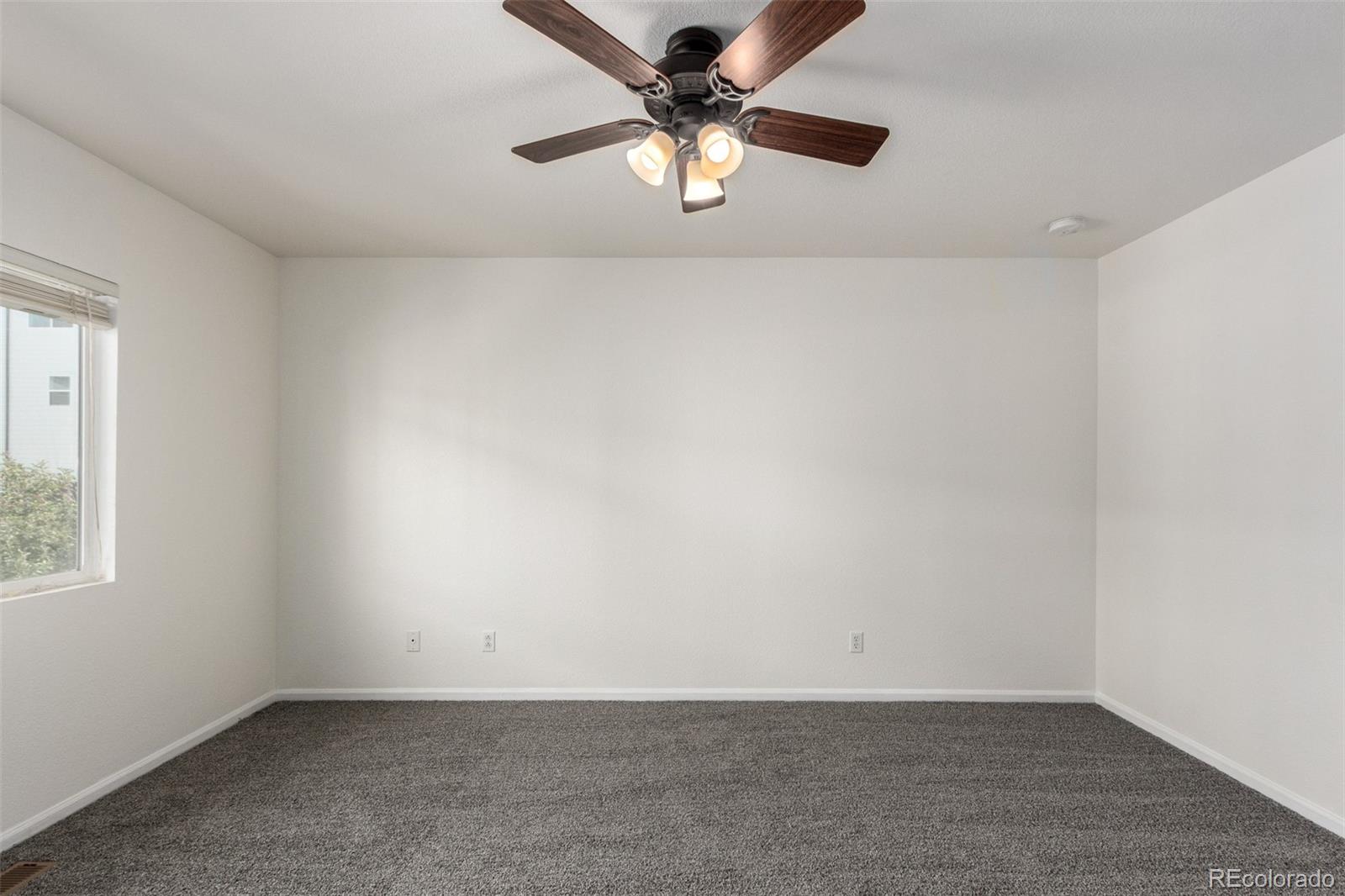 5850 Ceylon Street, Unit D Denver, CO 80249 - Photo 18 of 33 an empty room with a window and a ceiling fan