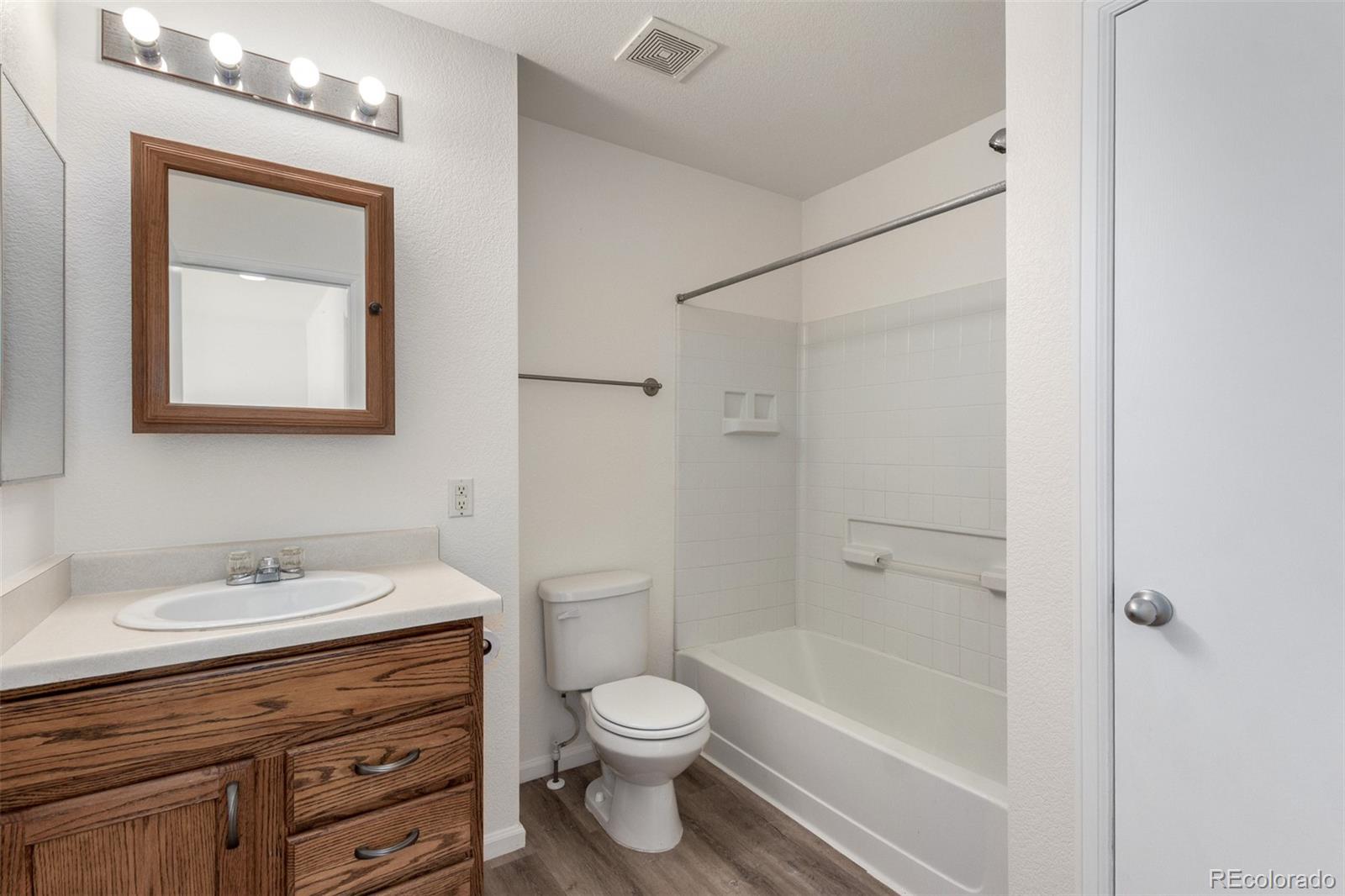 5850 Ceylon Street, Unit D Denver, CO 80249 - Photo 19 of 33 a bathroom with a toilet a sink a mirror a bathtub and vanity