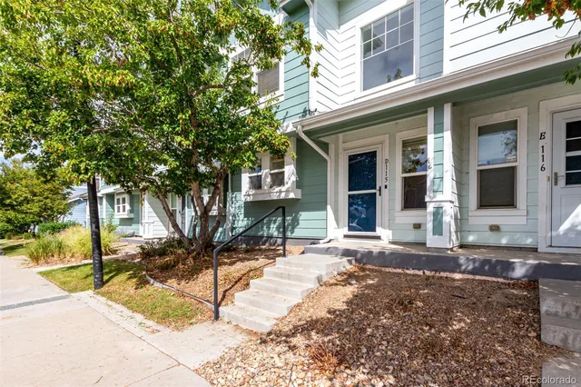 a front view of a house with a tree