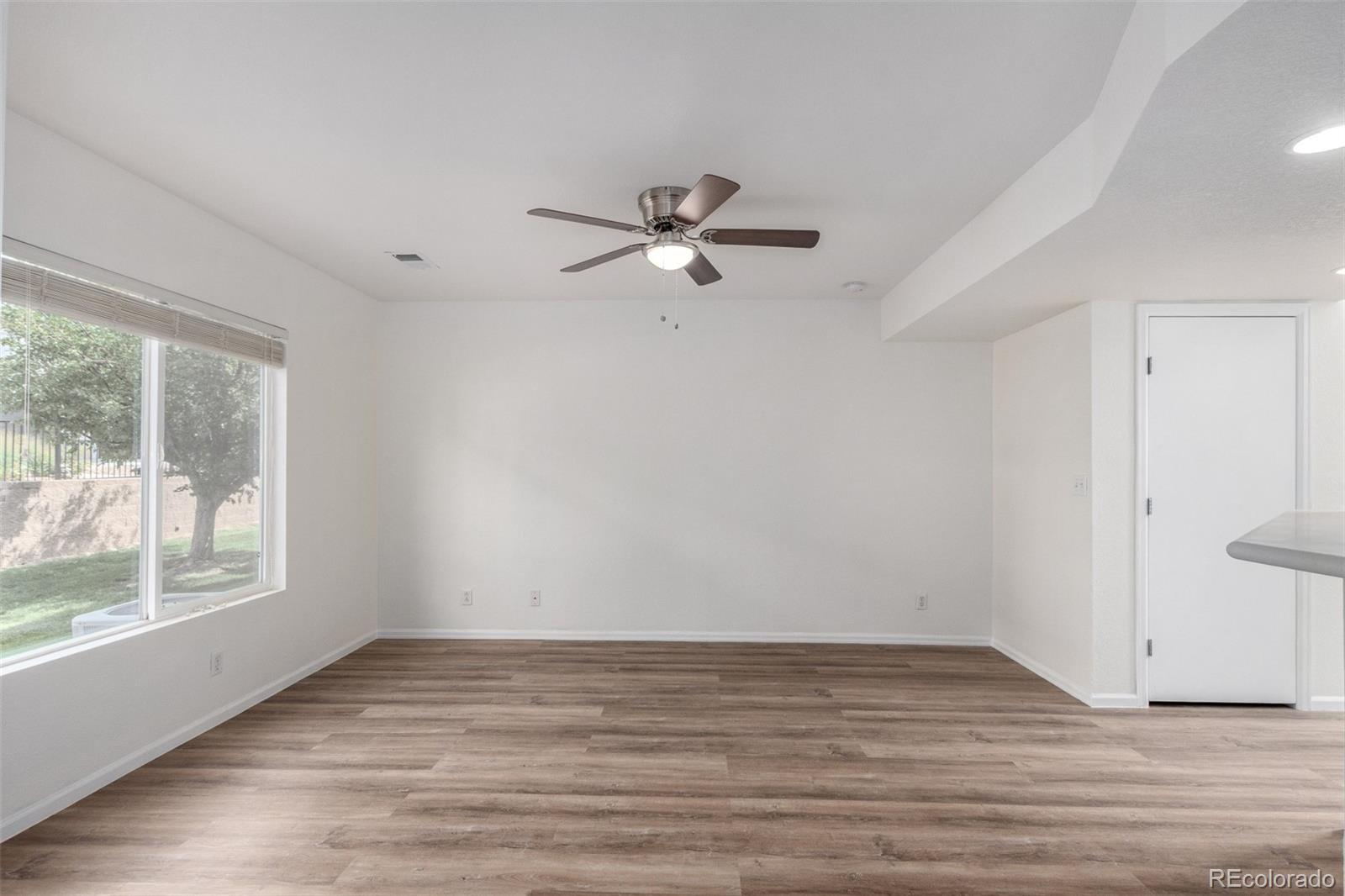 5850 Ceylon Street, Unit D Denver, CO 80249 - Photo 7 of 33 wooden floor in an empty room with a window