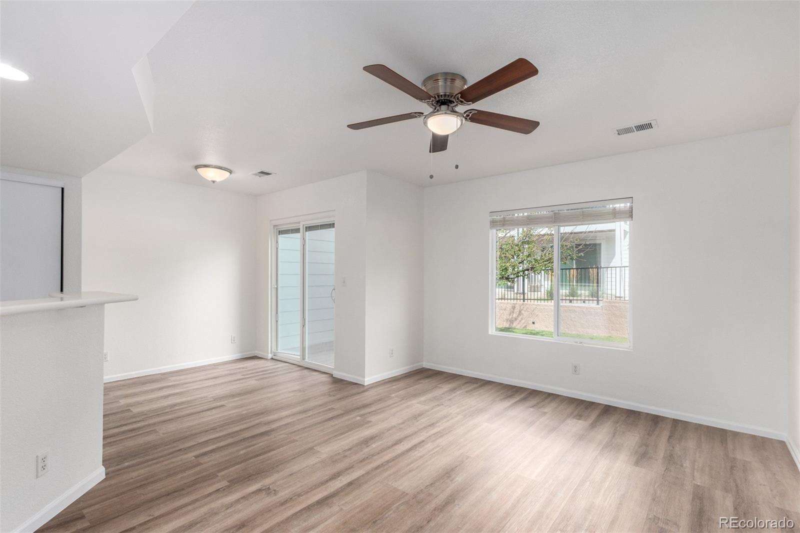 5850 Ceylon Street, Unit D Denver, CO 80249 - Photo 8 of 33 an empty room with wooden floor fan and windows