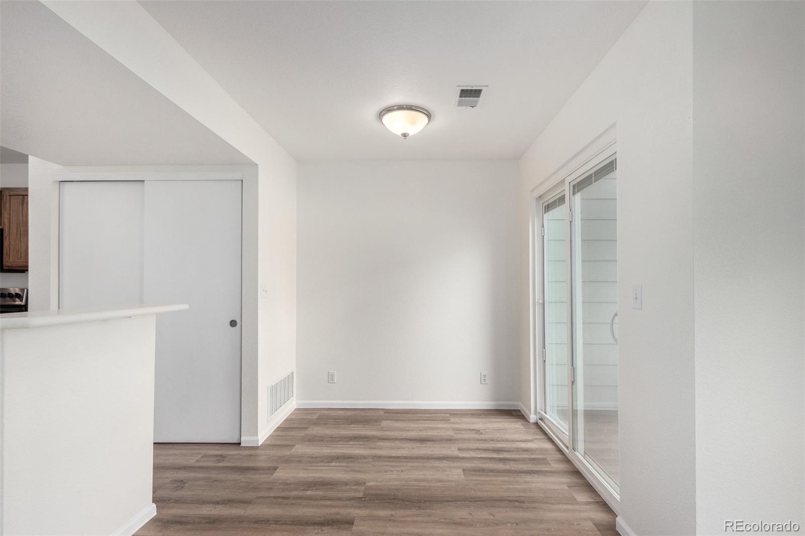 5850 Ceylon Street, Unit D Denver, CO 80249 - Photo 9 of 33 a view of an empty room with wooden floor and a window
