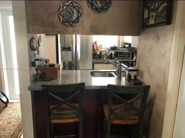 a kitchen view with a sink and chairs