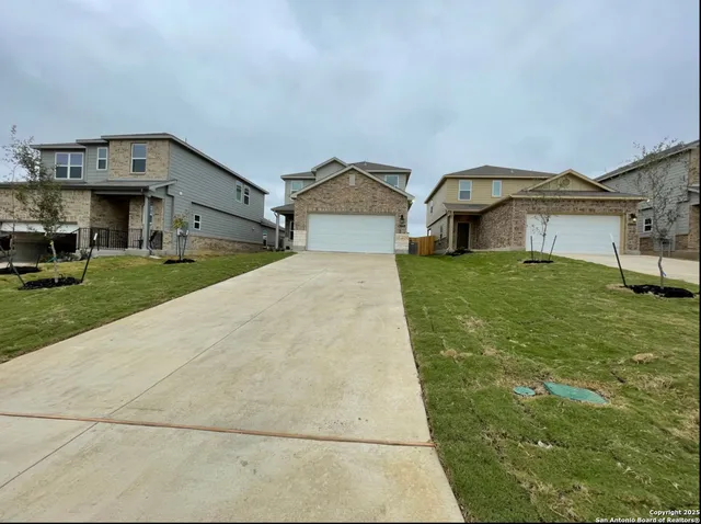 a view of a big house with a big yard and large tree