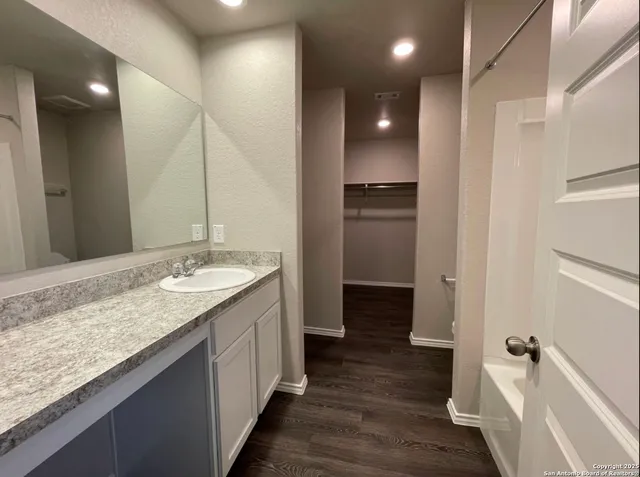 a bathroom with a granite countertop sink a toilet and a large mirror