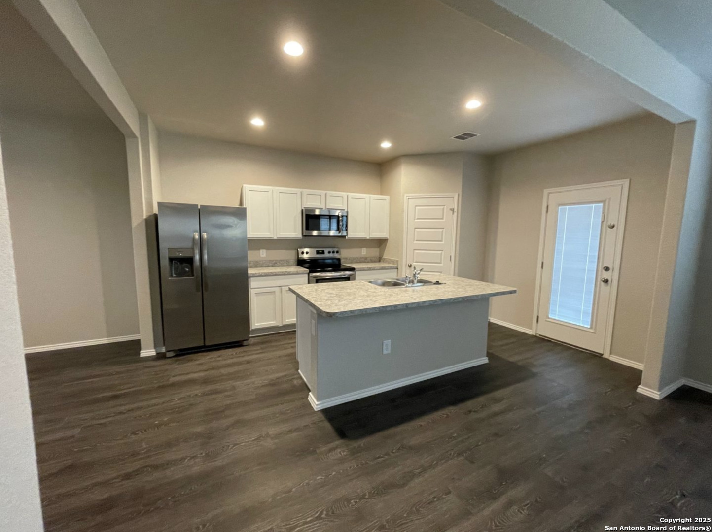 13018 Candace Way St. Hedwig, TX 78152 - Photo 2 of 15 a large kitchen with kitchen island a sink dishwasher a refrigerator and wooden floor