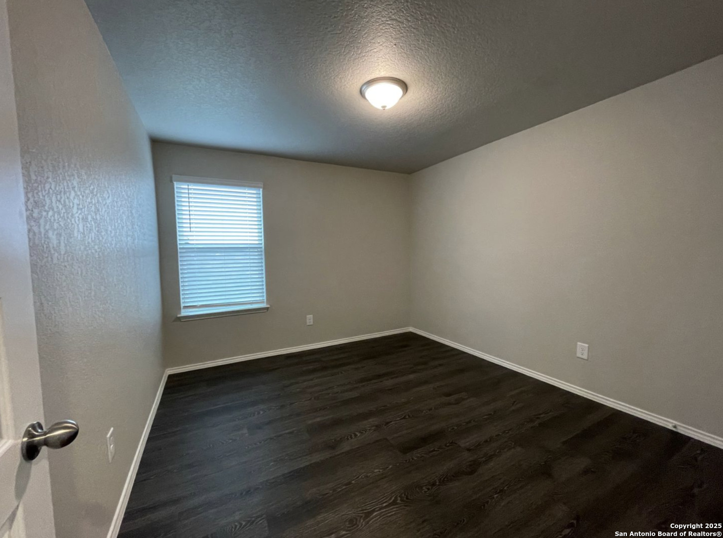 13018 Candace Way St. Hedwig, TX 78152 - Photo 7 of 15 an empty room with wooden floor and windows