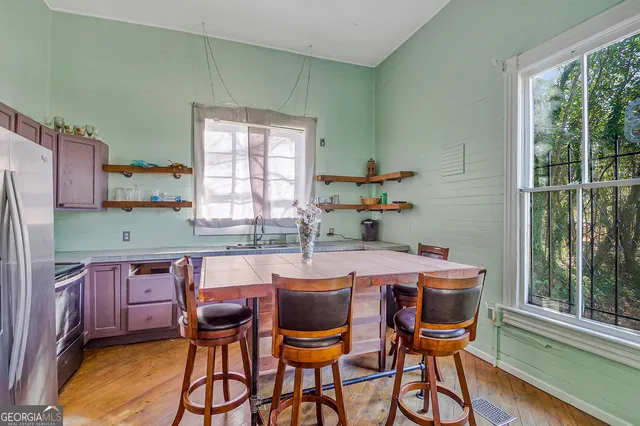 a kitchen with stainless steel appliances granite countertop a sink a stove and wooden cabinets
