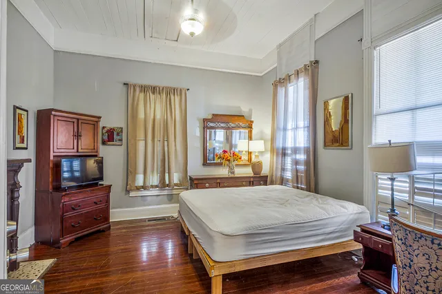 a bedroom with a bed window and a television