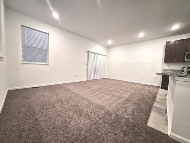 a view of a kitchen with refrigerator and white cabinets