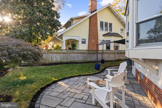 a view of house with backyard and sitting area